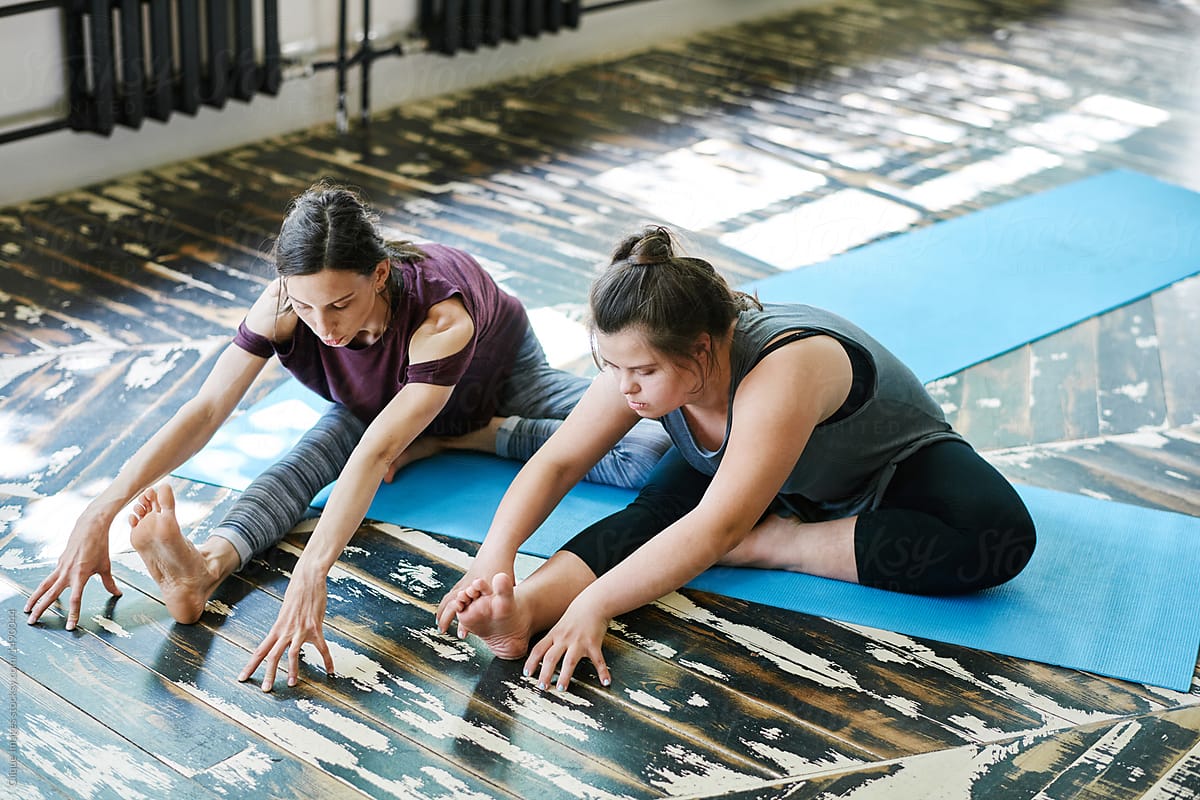 Two women practicing yoga stretches.